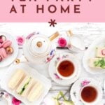 Flat lay of a tea set with cups, teapot, sandwiches, and macarons, featuring text on how to host a tea party at home.