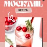 A festive cranberry mocktail with ice, cranberries, rosemary, and a red straw sits on a pink background.