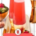 Two glasses of Strawberry Mimosas sit elegantly on a tray with fresh strawberries and a jigger close by. The label reads "Easy-to-Make Strawberry Mimosa" from Feast and West, capturing the refreshing essence of this delightful beverage.