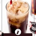 A glass filled with a fizzy, brown Tootsie Roll cocktail, topped with ice and a red-and-white striped straw. Small candies are partially visible around the glass.
