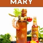 A Bloody Mary cocktail garnished with celery, shrimp, bacon, pickles, olives, and cherry tomato, with a bottle of hot sauce and fresh ingredients in the background.