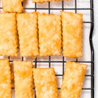 Rectangular cheese crackers on a black wire cooling rack.