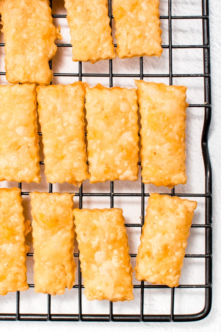 Rectangular cheese crackers on a black wire cooling rack.