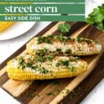 Two ears of Mexican street corn topped with cheese and herbs are placed on a wooden board, with ingredients visible in the background. The text reads "Mexican Street Corn Easy Side Dish.