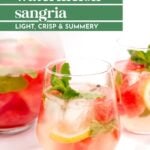 Glasses of citrus watermelon sangria with ice, lemon slices, watermelon chunks, and mint set on a white surface. Text reads: "Watermelon Sangria. Light, Crisp & Summery.