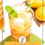A glass of Arnold Palmer with ice, lemon slices, mint, and a striped straw sits on a green napkin; lemons are in the background.