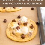 A chocolate chip cookie on a baking sheet lined with parchment paper, with chocolate chips and melted marshmallows visible. Text reads: "Chocolate Chip Cookies: Chewy, Gooey & Homemade.