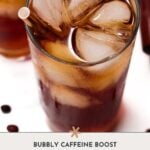 A glass of refreshing coffee soda with a straw sits on a white surface, paired with the text "Bubbly Caffeine Boost: coffee soda.