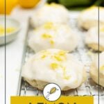 Iced lemon cookies topped with lemon zest on a cooling rack, with whole lemons and a green cloth in the background. Text reads "Lemon Cookies.