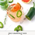 A spicy Paloma cocktail garnished with grapefruit, jalapeño slices, and rosemary, surrounded by a halved grapefruit, jalapeño, and a small bottle on a white surface.