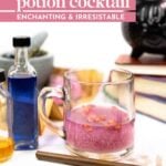 A glass mug with a pink drink topped with rose petals sits beside potion bottles, a wand, and a black cauldron on a table with books.