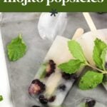 Icy popsicles with visible blackberries and mint leaves on a tray, labeled "blackberry mojito popsicles.