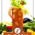 Tall glass of Bloody Maria cocktail garnished with celery, lime, shrimp, tomato, and olives. Fresh vegetables are visible in the background. Text reads "Bloody Maria.