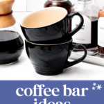 Two stacked black coffee mugs sit next to coffee syrup bottles and a pour-over coffee maker, perfect for inspiring new coffee bar ideas for mornings and parties.