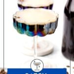 Two coupe glasses filled with batch espresso martini sit on a white surface, surrounded by coffee beans and a dark bottle. Text reads “Batch Espresso Martinis.”.