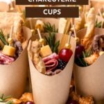 Brown paper cups filled with assorted charcuterie items like cheese cubes, meats, crackers, grapes, and herbs, with text overlay reading "Easy Charcuterie Cups.