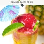 Close-up of a yellow glass of pineapple tiki punch with red topping, a lime wedge, green straw, and a blue cocktail umbrella, with a pineapple in the background.