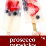 Two clear popsicles with visible strawberries and blueberries inside, held up on wooden sticks. Text below reads: "prosecco popsicles, sparkling ice pops.