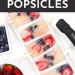 A rectangular tray of homemade popsicles with strawberries and blueberries inside, next to bowls of berries and a bottle of prosecco. Text says: How to Make Prosecco Popsicles.