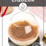 A glass of Cape Velvet liqueur topped with grated chocolate sits on a round marble coaster, next to a gold spoon and a cloth. Text reads "Cape Velvet Liqueur" and "Easy To Make.