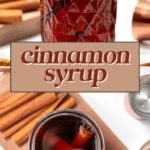 A jar of dark cinnamon syrup with cinnamon sticks inside, surrounded by cinnamon sticks and a bowl of brown sugar on a white surface.
