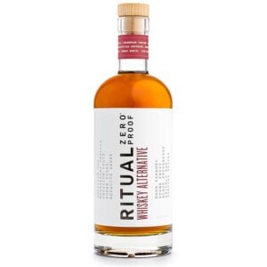 A bottle of Ritual Zero Proof Whiskey Alternative with a wooden cap and a white label featuring bold black and red text.