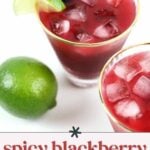 Two glasses of spicy blackberry margarita with ice, garnished with lime and blackberry; a whole lime is placed next to the drinks.