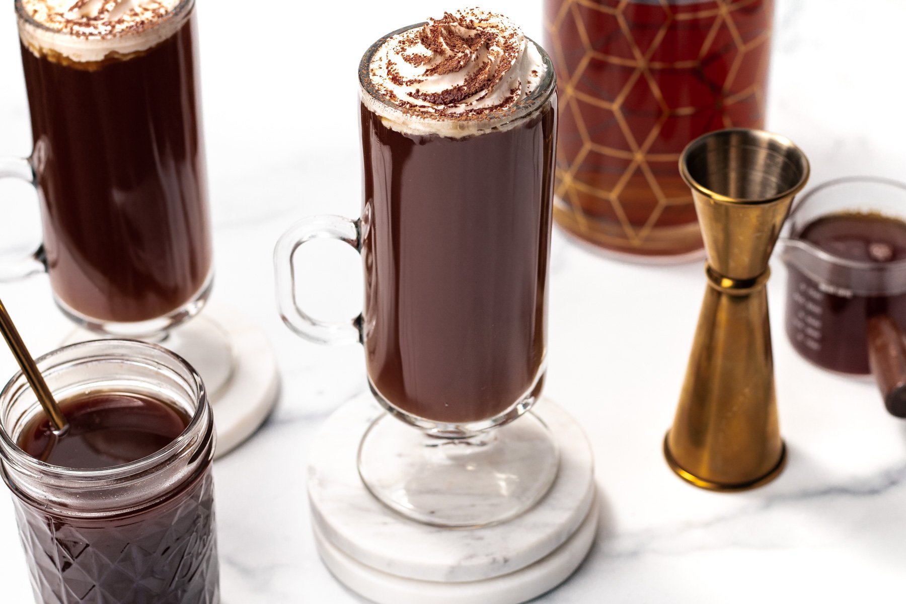 A glass of hot chocolate with whipped cream on top.