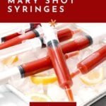 Syringes filled with Bloody Mary mix are arranged on a tray with ice and lemon wedges; text reads "how to make Bloody Mary shot syringes.