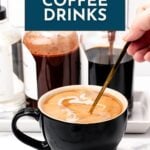 A hand stirs a black mug of coffee with cream; bottles of flavored syrups are visible in the background. A sign above reads "17+ Coffee Drinks.