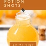 A round glass bottle filled with orange Halloween potion shot sits on a white surface; text reads "how to make Halloween potion shots, get the recipe.
