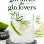 A glass of gin and tonic with ice, a lime wedge, and a sprig of rosemary sits on a coaster; text above reads "Gifts for Gin Lovers: 21+ gift ideas for gin enthusiasts.