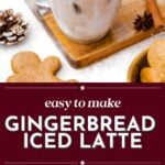 A glass mug of iced gingerbread latte topped with whipped cream and a gingerbread cookie, surrounded by gingerbread cookies and festive decorations.