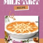 A cinnamon milk tart with a decorative powdered cinnamon pattern sits in a white dish, surrounded by flowers and a small bowl of cinnamon.