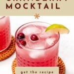 A glass of cranberry mocktail with ice, cranberries, and a lime wedge on a coaster, with text promoting a non-alcoholic recipe.