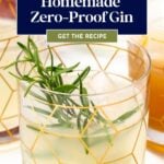 Close-up of a glass filled with homemade zero-proof gin, garnished with rosemary. Text overlay reads "Homemade Zero-Proof Gin" and "Get the Recipe.