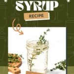 A glass jar filled with thyme syrup and fresh thyme sprigs sits on a white surface with additional thyme on a small wooden board nearby.