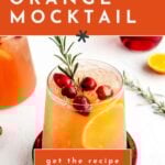 A glass of cranberry orange mocktail garnished with fresh cranberries, an orange slice, and rosemary, with a "get the recipe" button overlay.