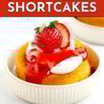 A small strawberry shortcake topped with whipped cream, strawberry sauce, and a fresh strawberry, served in a white ramekin. Text overlay reads "Mini Strawberry Shortcakes.