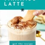 A glass mug of tiramisu latte topped with whipped cream and cocoa powder, with a hand dipping a ladyfinger biscuit. Text reads "how to make a TIRAMISU LATTE.