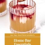 A cocktail in a textured glass is topped with a red liquid being poured from a spoon. Text reads: "Home Bar Essentials. Read More. feastandwest.com".