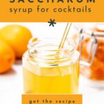 A jar of yellow oleo saccharum syrup with a stirrer, two oranges, and a jar of orange peel in the background; text reads “Oleo Saccharum syrup for cocktails.”.