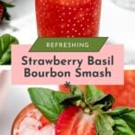 Two glasses of strawberry basil bourbon smash on ice, garnished with fresh strawberries and basil, with a hand placing a strawberry garnish on one glass.