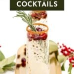 Champagne flute with cranberries, rosemary, and a sugar rim, labeled “25 Winter Cocktails.”.