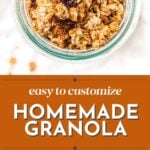 Jar of homemade granola with nuts and dried fruit, plus bowls and spoons of granola and yogurt on a white background.