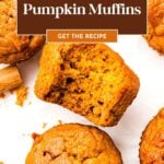 Pumpkin muffins on parchment, one with a bite taken out, with text: “Pumpkin Muffins. Get the Recipe.”.
