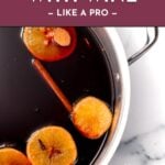 A pot of mulled wine with orange slices and cinnamon stick, with text: How to cook with wine.