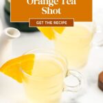 Two clear mugs of orange tea shot with orange slices on the rim, recipe text overlay above the drinks.