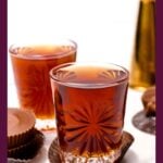 Two glasses of brown liquid with peanut butter cups on wrappers, labeled “Peanut Butter Cup Shot.”.