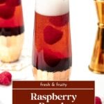 A tall glass of Raspberry Royale cocktail with raspberries, next to a jigger and loose raspberries.